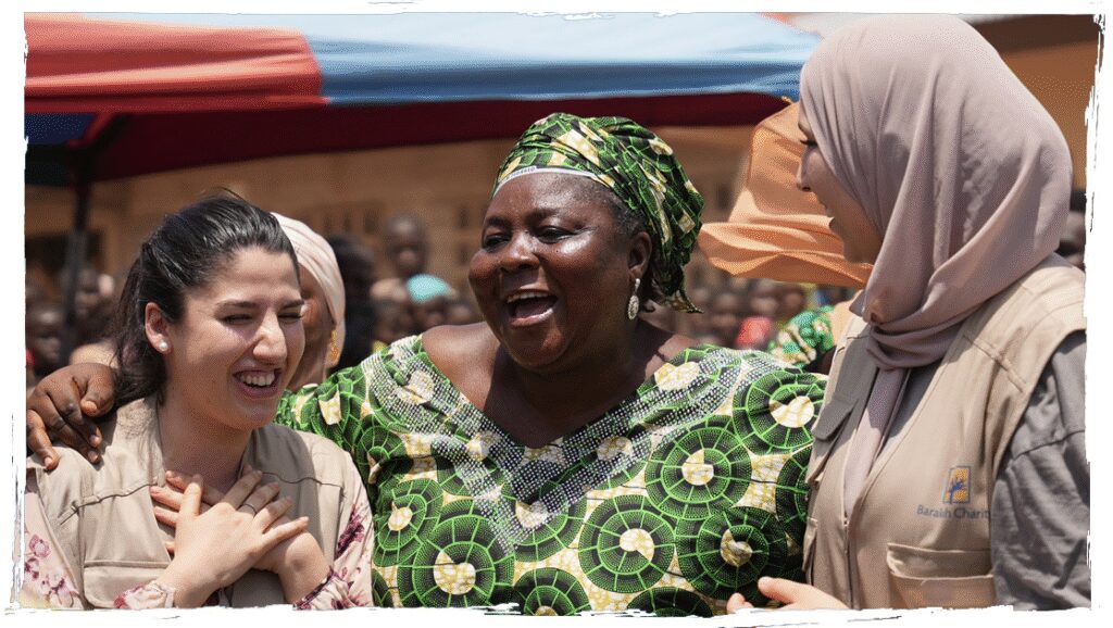 Barakah Charity female volunteers sharing a warm, joyful moment with a local woman in Africa.